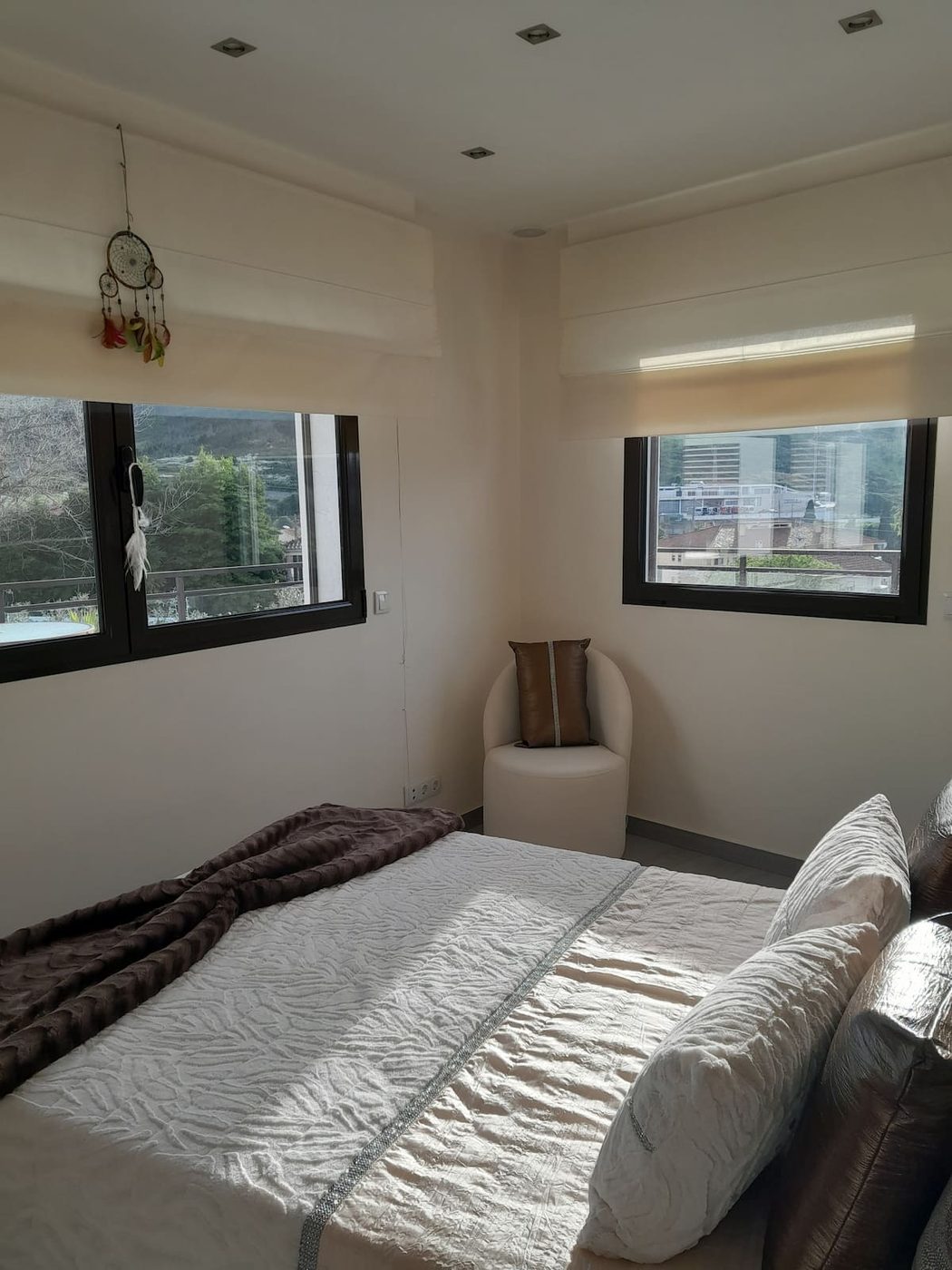 Quarto com duas janelas e vista para o campo