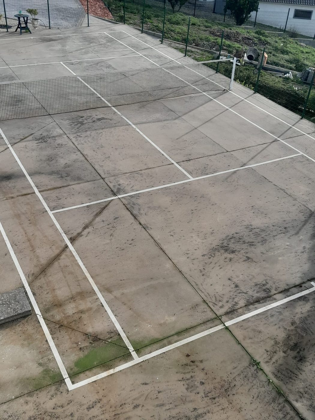 Campo de ténis exterior com rede e linhas marcadas