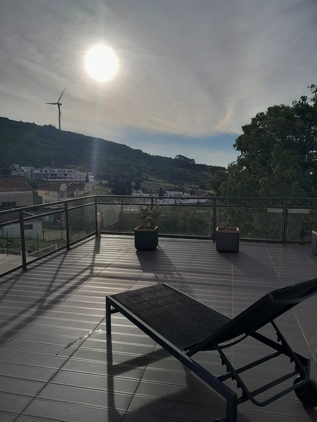 Terraço com espreguiçadeira virada para a serra ao pôr do sol